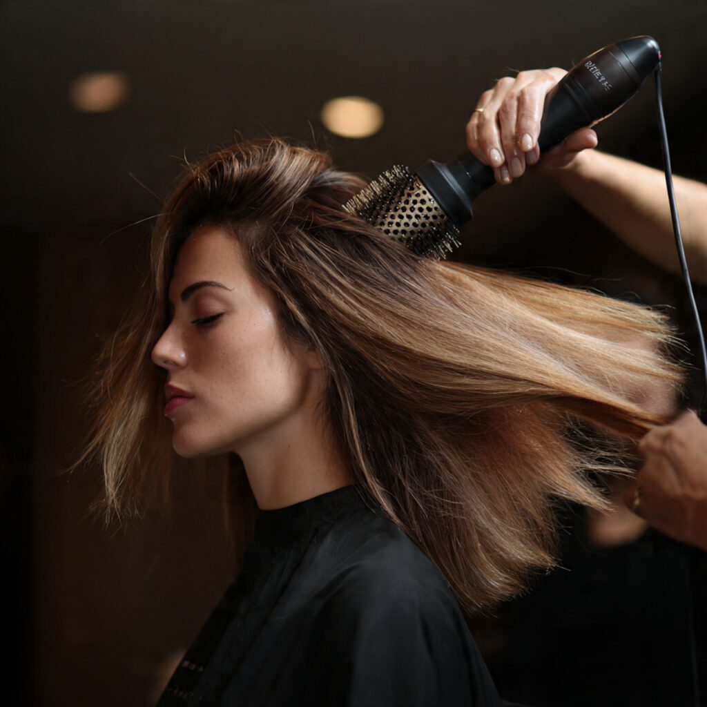 stylist_using_a_ceramic_round_brush_and